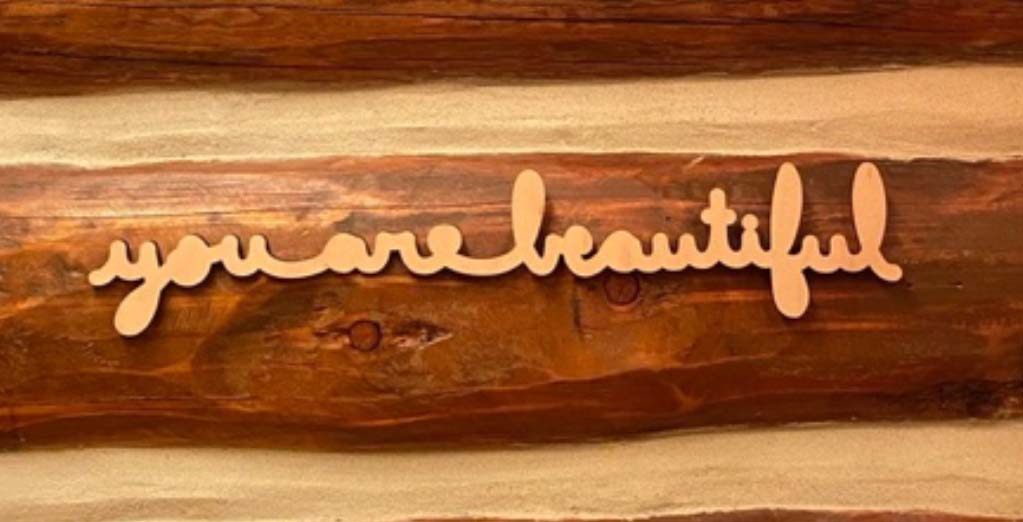 "You are beautiful" on a log cabin wall
